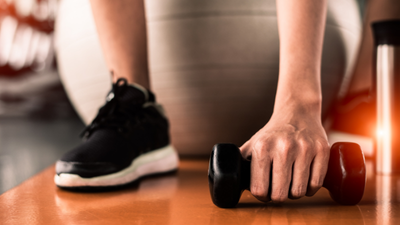 Premium_Personal_Training_East_Gwillimbury_Physotherapy_Service Close up of a person sitting on an excise ball holding a light weight