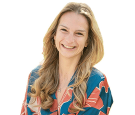 Jana-Blahutova-PTS - Premium Personal Training Smiling woman with long blonde-brown hair wearing a blue and pink patterned blouse.